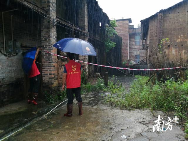 黨群志愿者冒雨拉起警戒線。